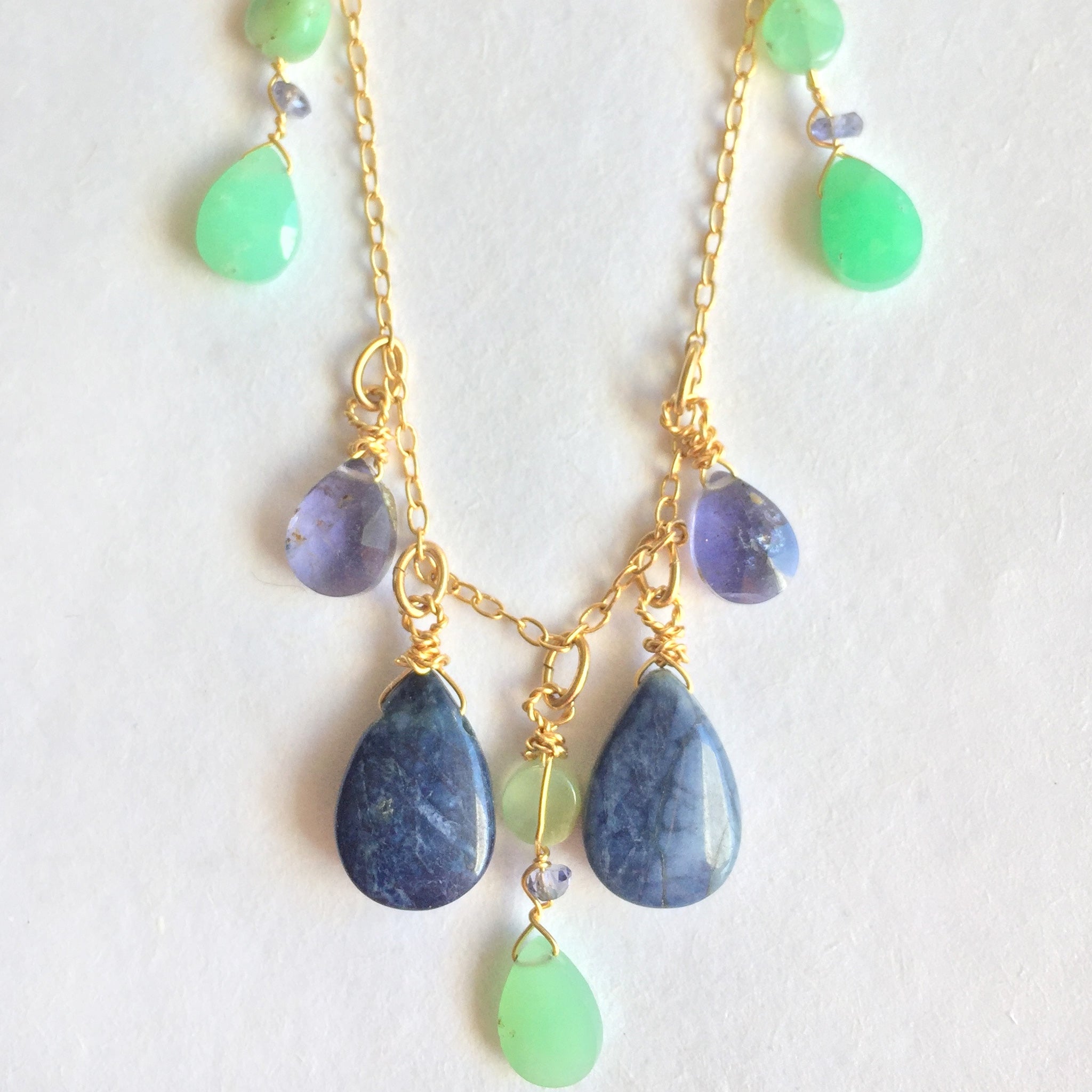 close-up of semi precious stone and gold necklace with iolite, lapis and chrysoprase 