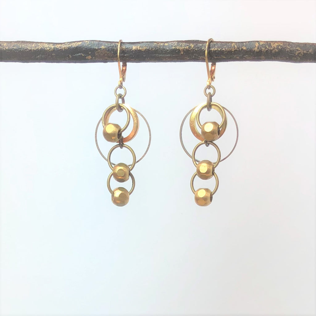 brass dangle earrings with smooth brass beads on white background