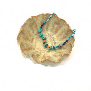 Hand knotted turquoise, lapis and howlite heishi beaded bracelet shown in ceramic dish