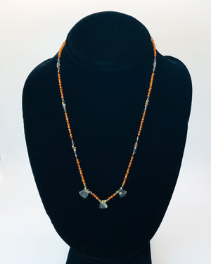 Knotted stone necklace designed with tourmilated quartz drops, carnelian, garnet, iolite, tanzanite and labradorite. Accented with faceted gold filled beads.